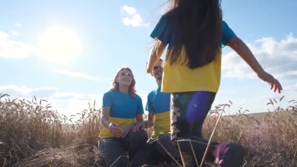 乌克兰家庭的母亲 父亲和女儿拥抱在麦田里 阳光灿烂的日子 儿童反对战争 乌克兰和俄罗斯之间的战争概念 — 图库视频影像