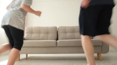 Anne, baba, oğul ve kızın güzel Amerikan ailesi oturma odasında kanepede oturuyor ve gülümsüyor, televizyon izliyorlar. Mutlu aile