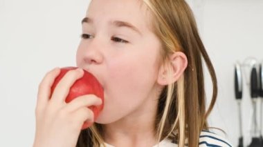 Şirin bir Avrupalı çocuk büyük bir kırmızı elma yiyor. Çocuklar için yararlı ürünler. Sağlıklı yiyecekler. Meyveli vitaminler