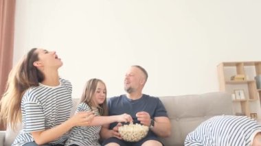 Büyük mutlu bir aile hafta sonu evde eğleniyor. Baba, anne ve iki çocuk kanepede oturmuş TV 'de komik bir film izlerken patlamış mısır yiyorlar..