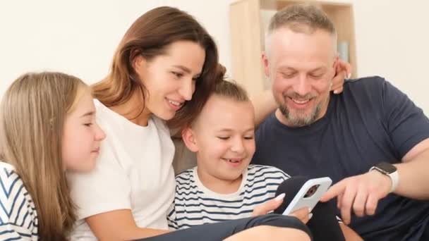 家族のお父さんのお母さんの息子と娘の電話と笑顔を見てください ソーシャルネットワークの使用 幸せな家族 — ストック動画