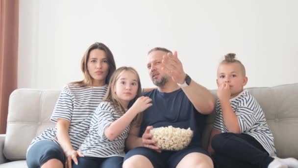 美国家庭在家里看电影 在沙发上吃爆米花 在公寓里享受休闲和娱乐 — 图库视频影像