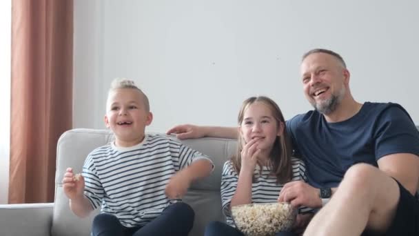 Pai Mãe Filha Estão Deitados Sofá Comendo Pipocas Assistindo Uma — Vídeo de Stock