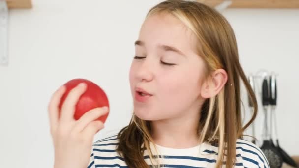 子供は大きなジューシーな赤いリンゴを食べ 女の子は朝食のために新鮮な果物を食べます 子供の健康な歯 — ストック動画