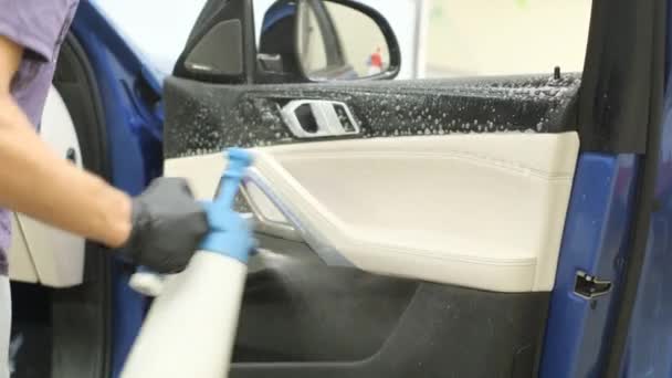 Trabajador Lavado Autos Aplica Detergente Una Silla Auto Joven Limpia — Vídeo de stock