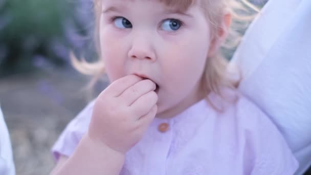 美しい赤ん坊の女の子は彼女の親の腕に坐っている間おいしい果実を食べる 空腹の子供だ 閉じろ — ストック動画
