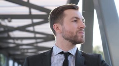 Kameraya bakıp gülen genç bir iş adamının portresi. Bir iş adamının mutlu yüzü. İş konsepti