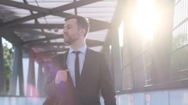 Takım elbiseli bir adam havaalanı terminalinde yürüyor, uçağa biniyor. Genç iş adamı. İş konsepti