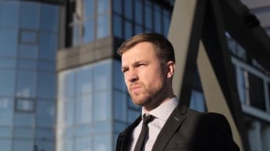 Cam iş merkezinin arka planında Amerikalı bir işadamı var. Genç bir iş adamının portresi. Modern şirket yöneticisi