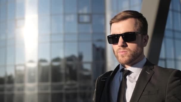 Porträt Eines Jungen Geschäftsmannes Mit Sonnenbrille Der Vor Dem Hintergrund — Stockvideo