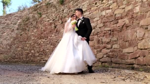 Belas Noivas Contexto Uma Parede Pedra Abraçam Beijam Casal Feliz — Vídeo de Stock