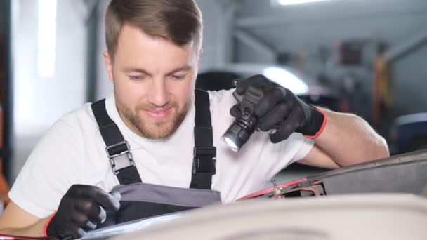 Zbliżenie Zadowolonej Atrakcyjnej Mechaniki Samochodowej Latarką Terminowa Naprawa Samochodu Garażu — Wideo stockowe