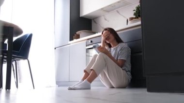 Mutfakta üzgün bir yetişkin kadın oturuyor, o günlük işten dolayı yorgun. Kadın sorunları konsepti. Gerçek insanlar. Uzayı kopyala Yavaş çekim