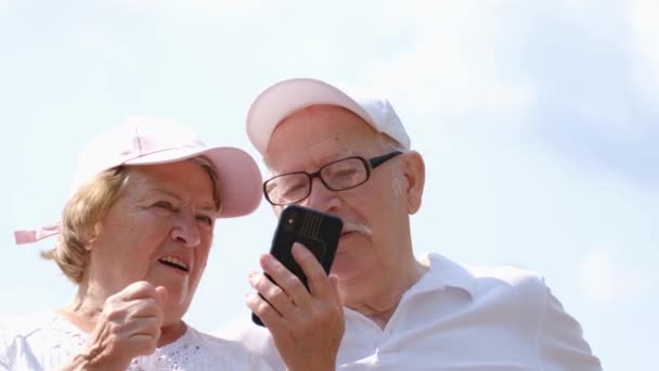 Pensionati Americani Rilassano Nel Parco Usando Uno Smartphone Divertendosi Felice — Video Stock