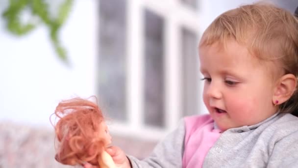 Retrato Una Hermosa Niña Jugando Con Una Muñeca — Vídeos de Stock