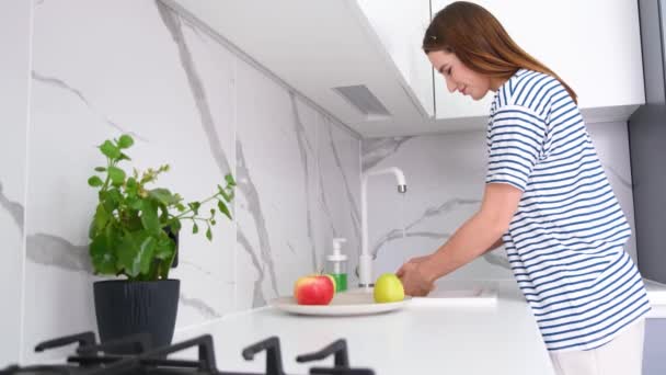 若いオーストラリアの母親は シンクでリンゴを洗い 健康的な食事をします 幸せな家族 — ストック動画
