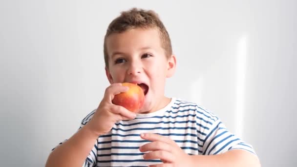 朝食に大きな熟した桃を食べる赤ん坊の少年の肖像画 果物と健康的な食事 — ストック動画