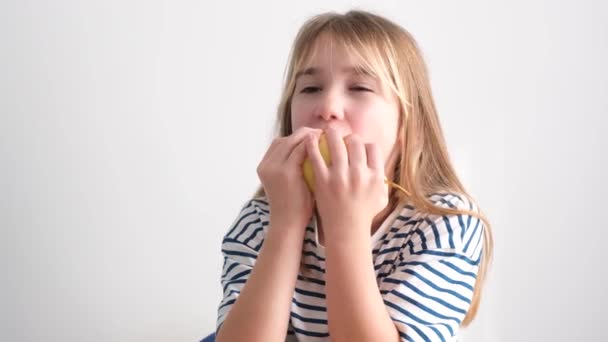 美しい少女が白い背景に熟した梨を食べています おいしい秋の果物 菜食主義者は子供 — ストック動画