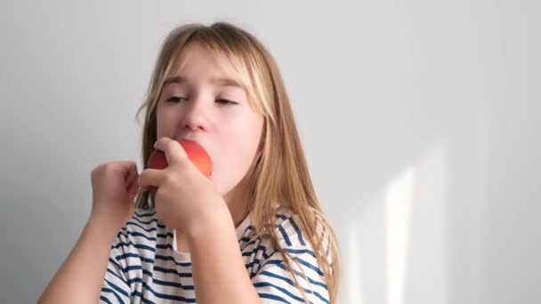 一个小女孩正在吃一个成熟的多汁的桃 健康饮食与水果 水果富含维生素C — 图库视频影像
