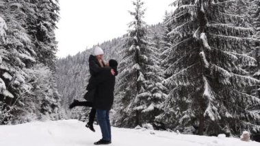 Bir çift, kış ormanlarında yürüyen bir adamla bir kadına aşık. Kışın dağlarda eğlence ve turizm. Güzel karla kaplı Noel ağaçları.