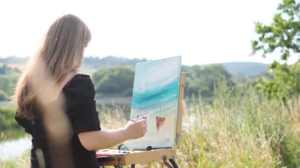 一个年轻的艺术家女孩用彩绘画一幅画 油画的特点 黄鼠狼 — 图库视频影像