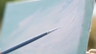 Tuvale resim çizmenin yakın çekimi. Easel, tuval, boya, fırça, spatula, çözücü.