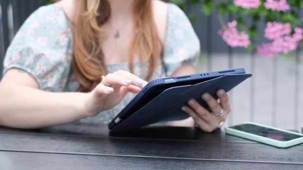 女の子は夏のカフェのテーブルに座っている間 タブレット上で動作します ソーシャルメディアのライフスタイルの概念 顔のないビデオフレーム — ストック動画