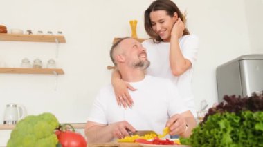 Bir adam karısı için yemek pişirir, bir ilişkide samimi bir aşk. Mutfakta birbirine aşık bir çift. 4k video