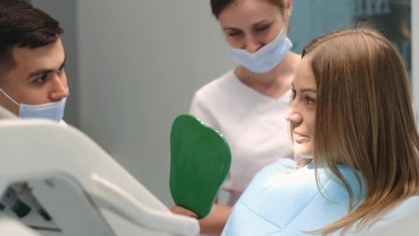 Zufriedene Junge Kundin Sitzt Zahnarztstuhl Und Betrachtet Ihre Zähne Spiegel — Stockvideo