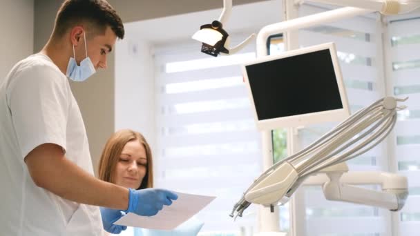 Ένας Νεαρός Οδοντίατρος Δείχνει Μια Ακτινογραφία Του Στόματος Των Ασθενών — Αρχείο Βίντεο
