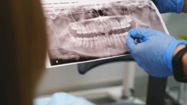 Ένας Νεαρός Οδοντίατρος Δείχνει Μια Ακτινογραφία Του Στόματος Των Ασθενών — Αρχείο Βίντεο