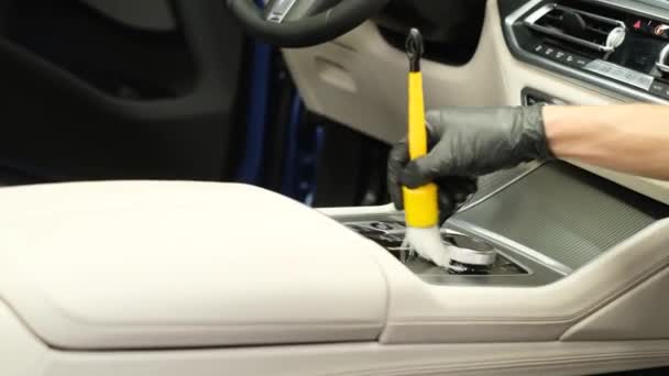 新しい車のギアボックスを掃除する ブラシで車のインテリアのプロのクリーニング 人間の手は車の内部をきれいにする — ストック動画