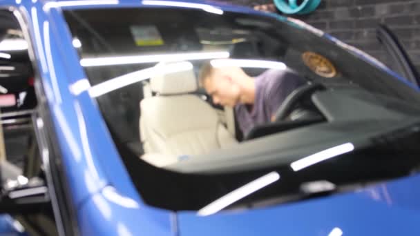 Genç Sarışın Bir Adam Garajda Yeni Mavi Arabasını Temizliyor Mikrofiber — Stok video