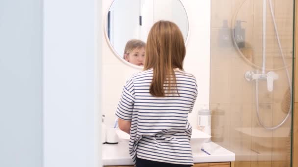 儿童口腔卫生 一位漂亮的少女在浴室的镜子前仔细刷牙 — 图库视频影像