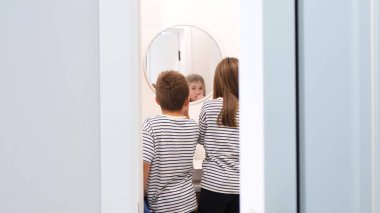 Okul çağındaki erkek ve kız kardeşler diş fırçasıyla dişlerini fırçalıyorlar, çocuklar okula gidiyor, ağız bakımı....