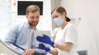 The dentist and the patient discuss the dental treatment plan. Timely detection of dental diseases and their treatment