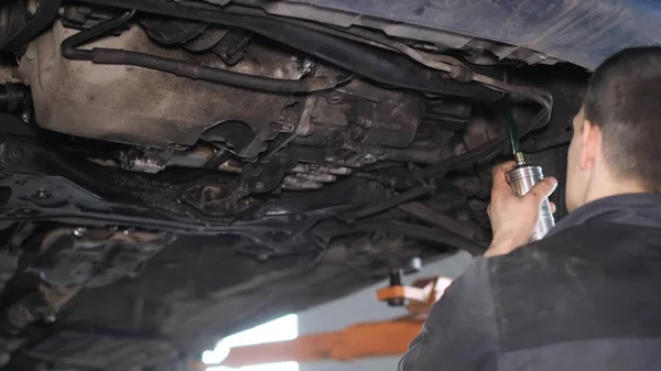 A mechanic repairs a car. Replacement of brake discs and pads. Car repair in a car service. 4k video