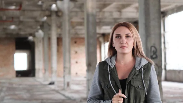 A Ukrainian girl sings on the ruins of war. Consequences of the war in Ukraine. The girl prays for an end to the war. War in Ukraine. A woman in a ruined building