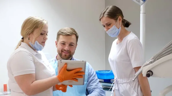 Handsome Bearded Young Patient Company Two Female Dentists Looking Apple — Stock Photo, Image