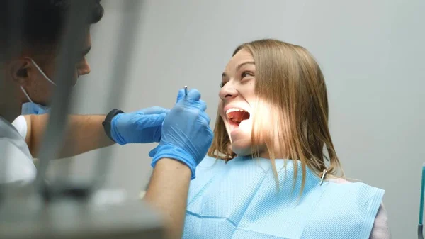 在一个现代化的诊所里 害怕的女孩在治疗牙齿 胆怯和害怕牙医 牙医检查病人的牙齿 — 图库照片