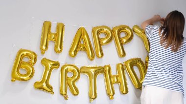 Bir kız doğum gününü kutluyor ve doğum günü balonlarına sarılıyor. Tatil kavramı