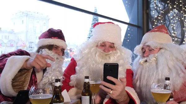 Three Friends Santa Claus Using Smartphone Santa Claus Holding Smart — Stockfoto