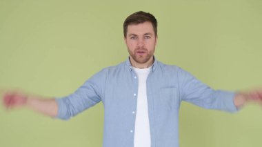 Stüdyoda arka planda izole edilmiş beyninde patlama jesti gösteren bir adam. Çocuk parmaklarıyla kulağını kapadı ve bağırdı. 4k video