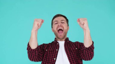 Joyful bearded guy in a checkered shirt, looking up and shouting with happiness, shouts Yes. Surprised and happy man close up. 4k video