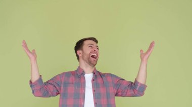 Handsome man looking up and shouting with happiness he is surprised and raised his hands up, boundless happiness. 4k video