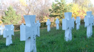 Yazın mezarlık, yeşil çimlerde bir sürü beyaz mezar. Cenaze hizmetleri