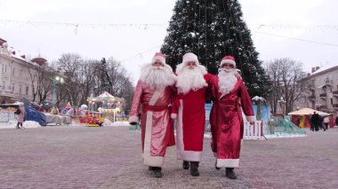 Noel zamanı. Bir grup Noel Baba şehrin merkezinde yürüyor, arkalarında da ana Noel ağacı var. Yeni 2023 ve Noel konsepti