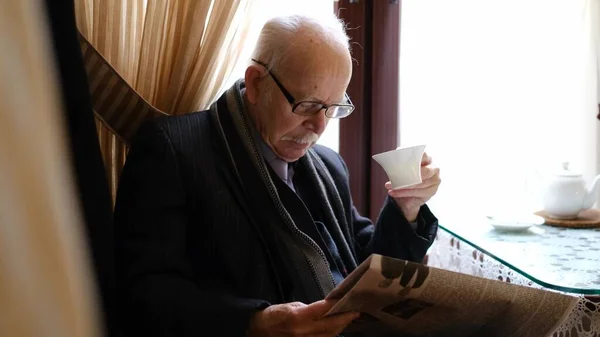 Elderly Man Sitting Kitchen Table Reading Newspaper Gray Haired Grandfather — Stok fotoğraf
