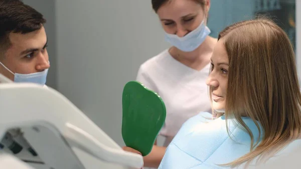 Jovem Cliente Satisfeita Senta Cadeira Dentária Examina Dentes Espelho Tratamento — Fotografia de Stock