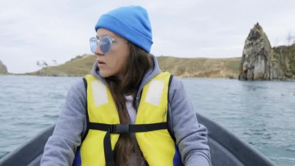 少女はバイカル湖の櫓に乗って船に乗り込む 女は漕ぎに従事している — ストック動画